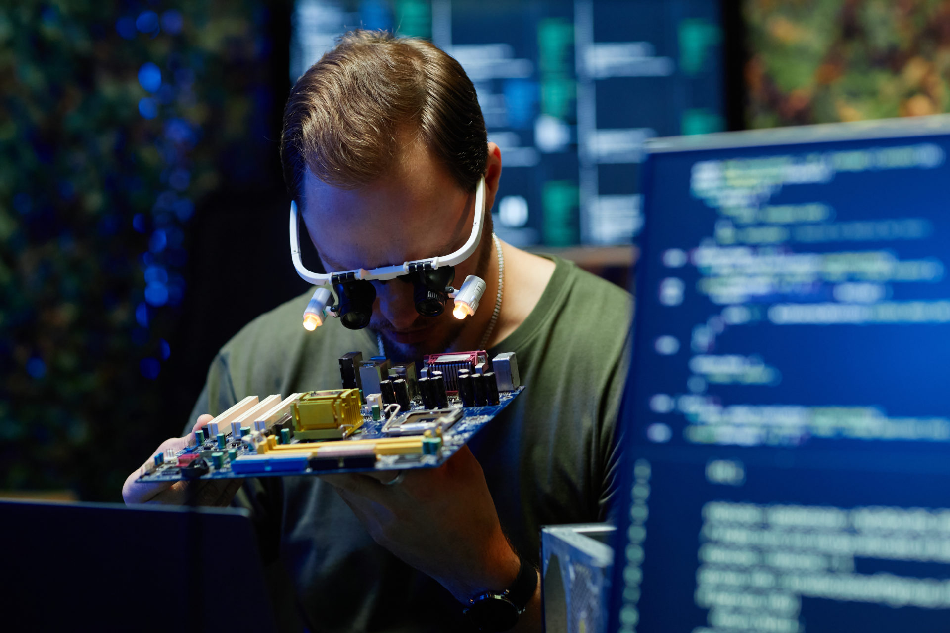 Young military officer or repairman checking details of processor